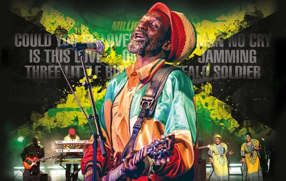 A promotional poster for Legend - the music of Bob Marley, showing a performer impersonating bob marley against a backdrop of the Jamaican flag