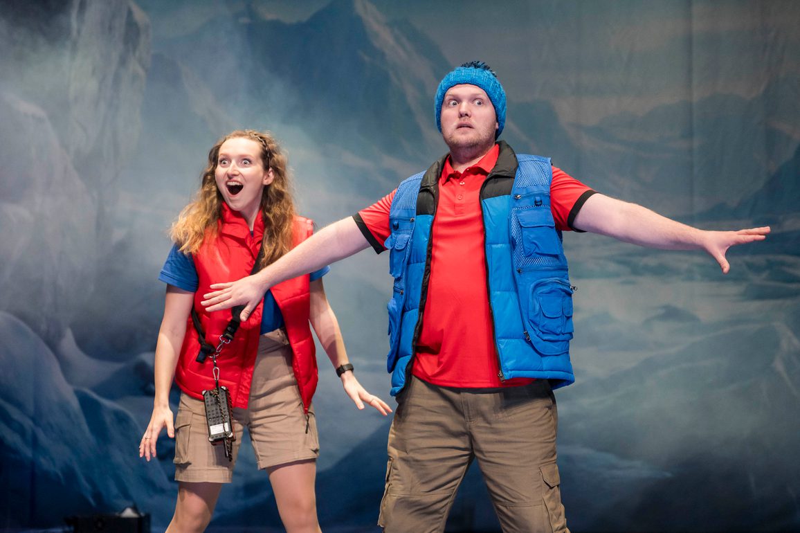 two cast members in warm bright clothes