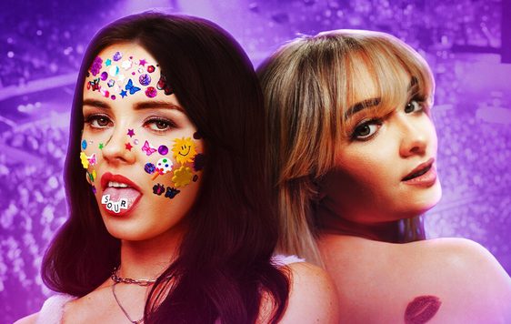 Two performers posing as Sabrina Carpenter and Olivica Rodrigo stand back to back in front of a purple background.