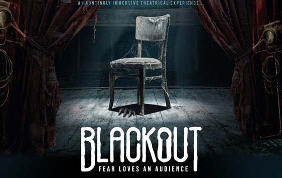 A dusty chair covered in cobwebs sits under a spotlight on an old stage. The show title is shown beneath "Blackout, Fear Loves an Audience".