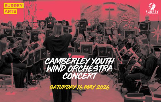 A red and black image showing an orchestra gathered in a semi-circle with a conductor wearing all black. "Surrey Arts" logo is in the top left corner and the show title "Camberley Youth Wind Orchestra" is in the centre