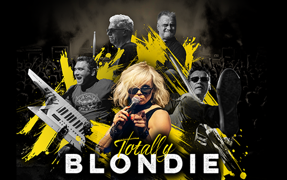 Chloe Buswell poses as Debbie Harry of the band Blondie. She is holding a microphone and wearing sunglasses and is shown with band members behind her against an artistic background of black with yellow paint splatters.