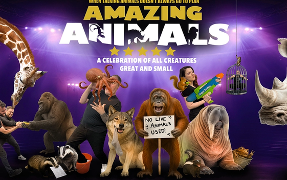 A collection of animals including a giraffe, gorilla, octopus, wolf, orangutan, walrus and rhinoceros are shown with performers with purple lights behind. The orangutan is holding a sign which say "No live animals used".
