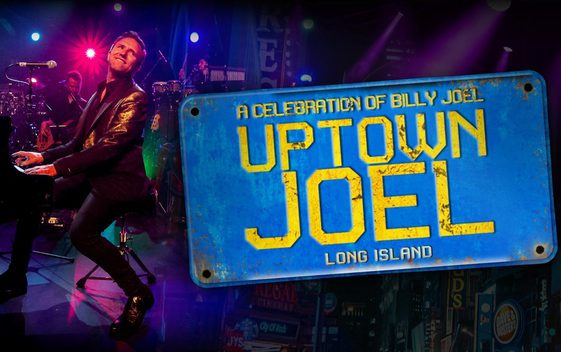 Darren Reeves playing piano wearing a black shirt and jacket. A blue sign is next to him with the words "A celebration of Billy Joel, Uptown Joel".