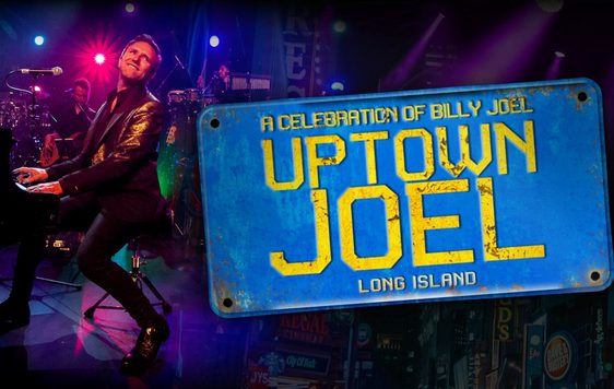 Darren Reeves playing piano wearing a black shirt and jacket. A blue sign is next to him with the words "A celebration of Billy Joel, Uptown Joel".