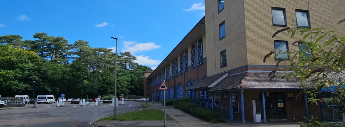 A multistorey car park building with entrance barriers on the left