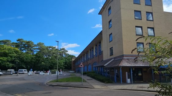 A multistorey car park building with entrance barriers on the left