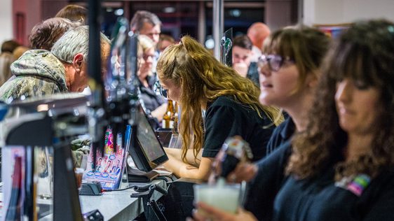 Three members of staff are serving customers across the bar at Camberley Theatre