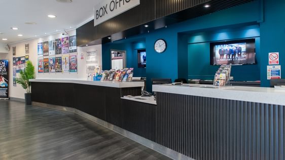 The Box Office counter at Camberley Theatre with leaflets on the counter and posters on the wall